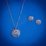 Diamond pendent set with layered heart design and matching earrings in 14k gold