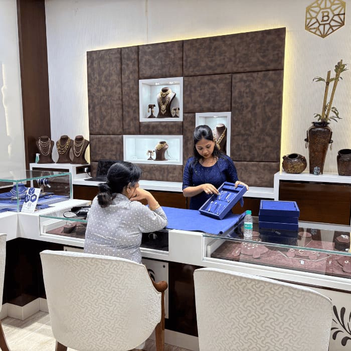 jeweler presenting gold necklace collection to client